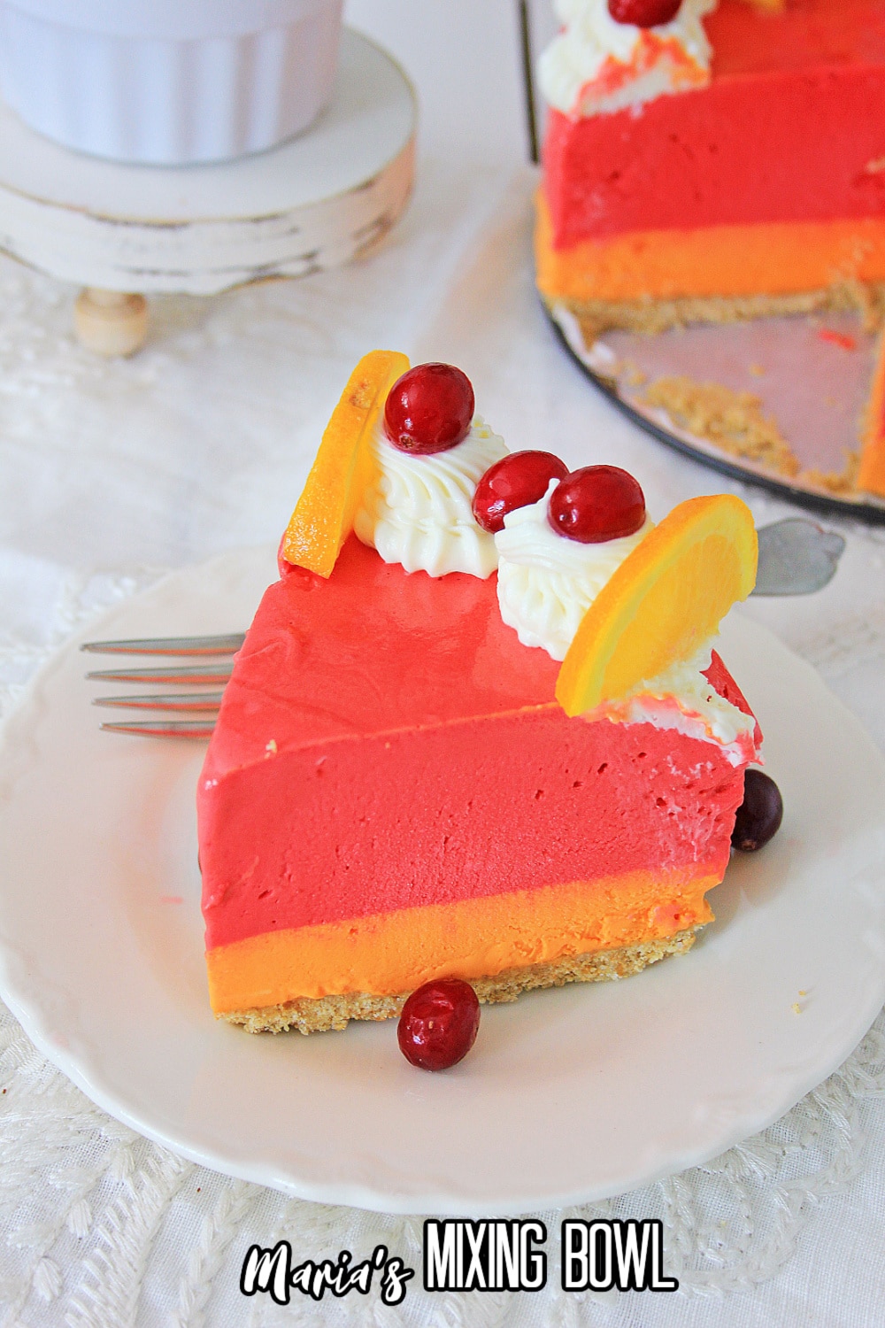 slice of orange cranberry cheesecake on a white plate