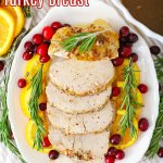sliced turkey breast on a white plate granished with oranges and cranberries
