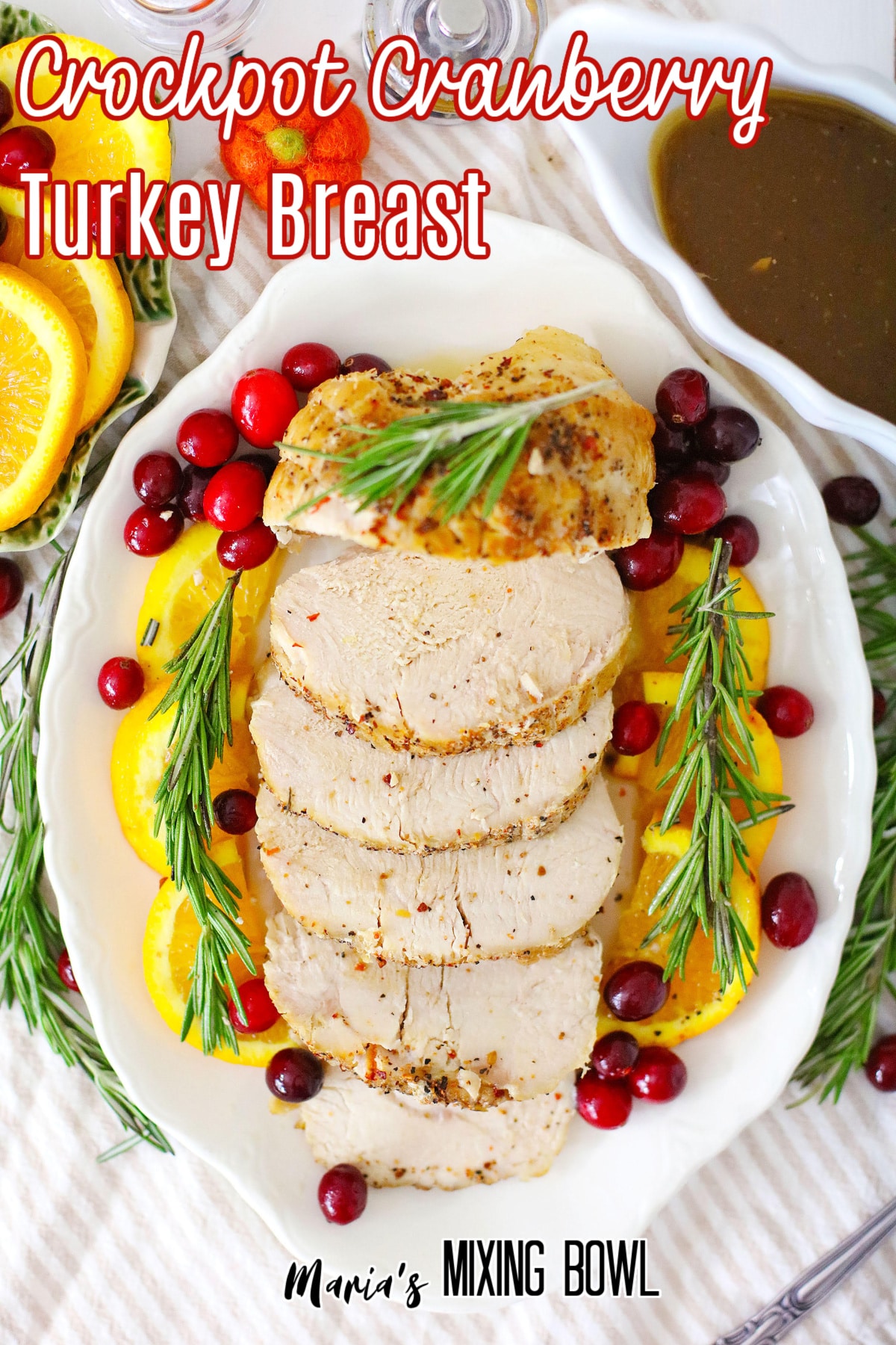 sliced turkey breast on a white plate granished with oranges and cranberries