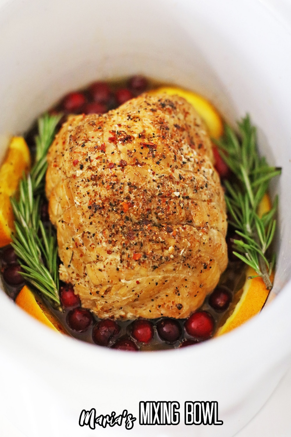 cooked meat on a a bed of oranges in a slow cooker