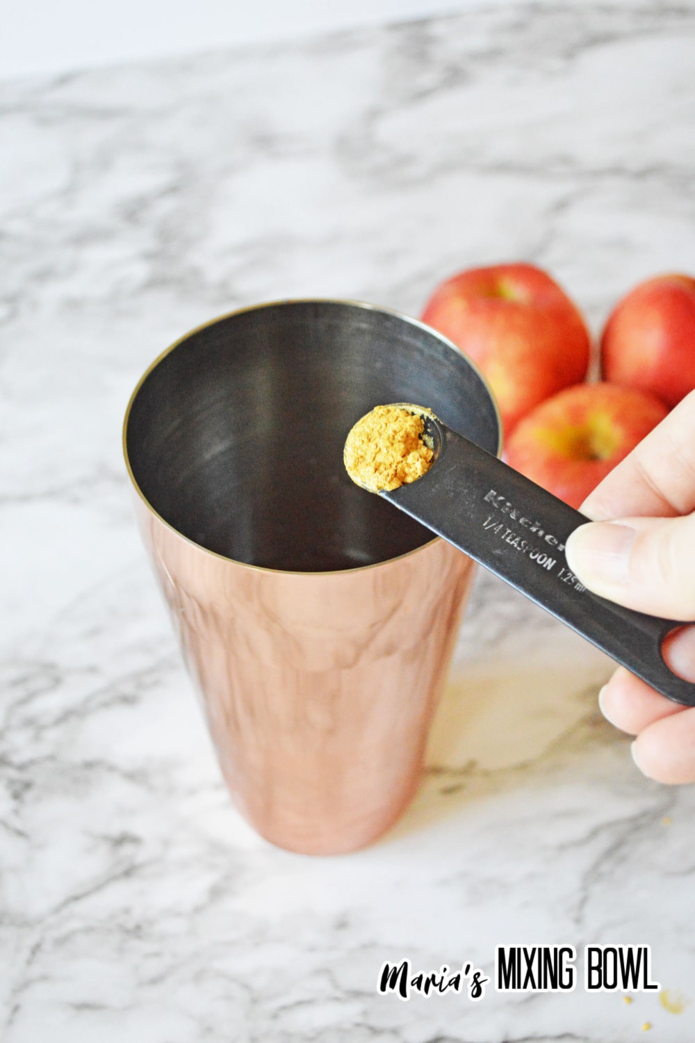 seasoning being added to a cocktail shaker