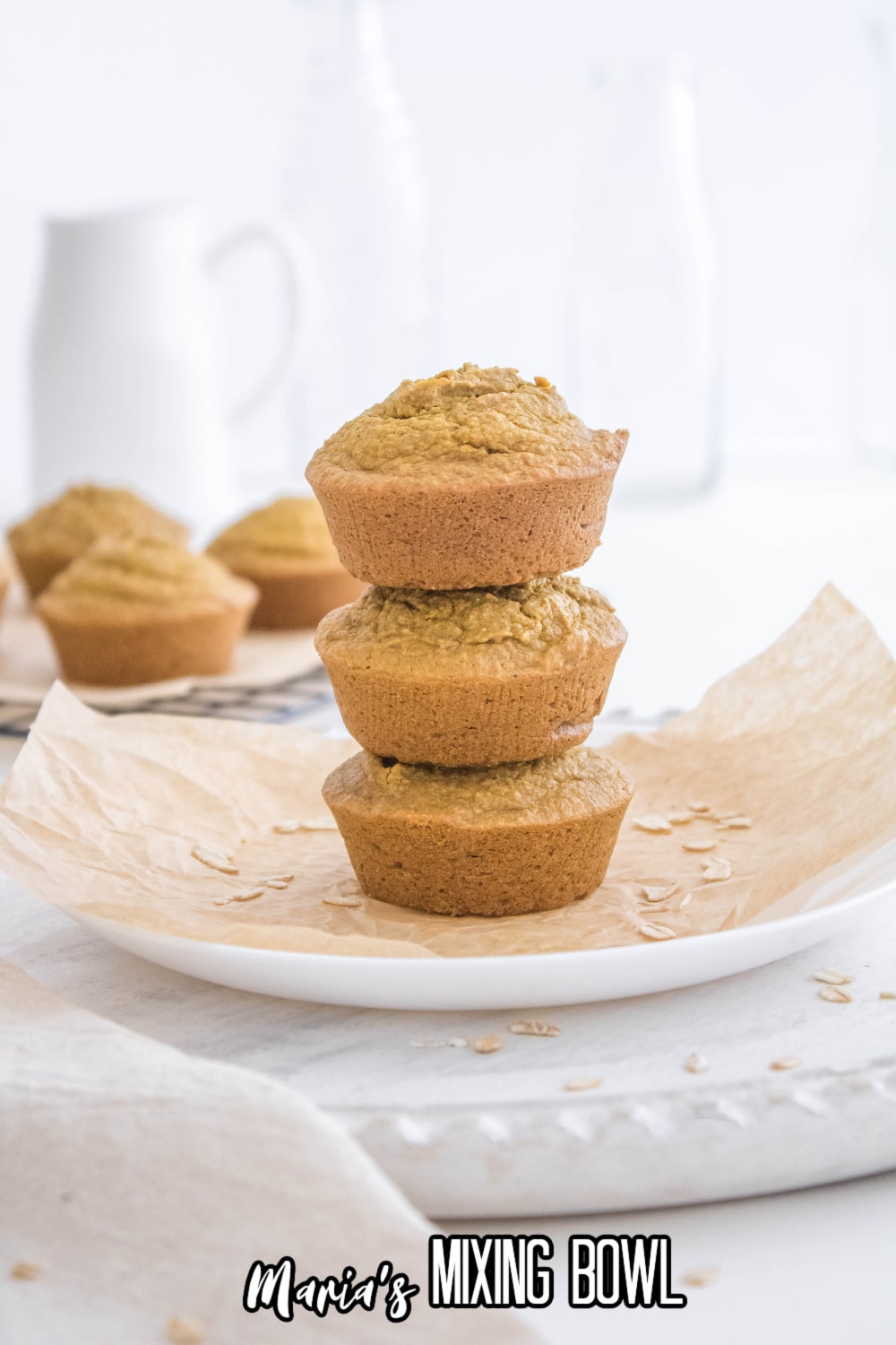 three stacked pumpkin oatmeal muffins on a white plate