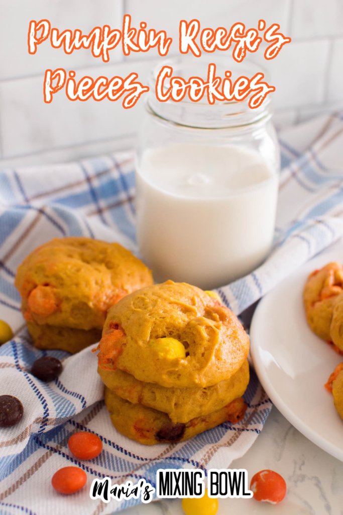 pumpkin reese's pieces cookies on a blue, white and gray kitchen towel