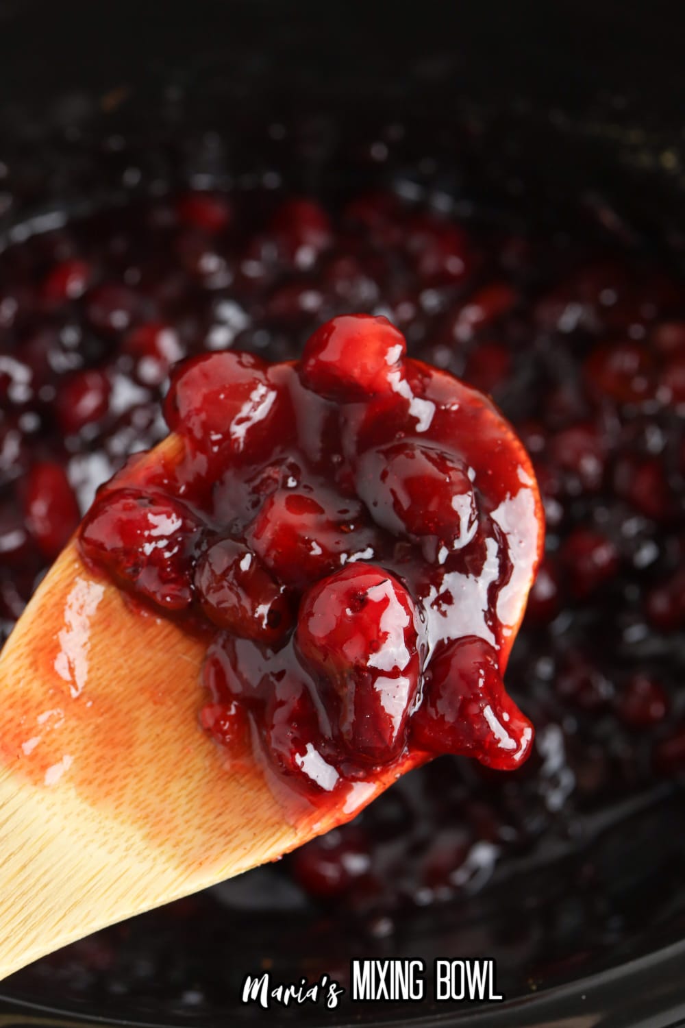 wooden spoon full of slow cooker cranberry sauce