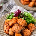 air fryer salmon bites on a plate with salad as a side
