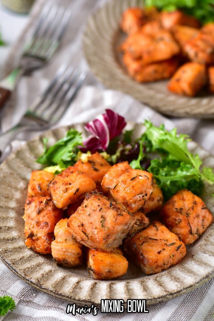 air fryer salmon bites on a plate with salad as a side