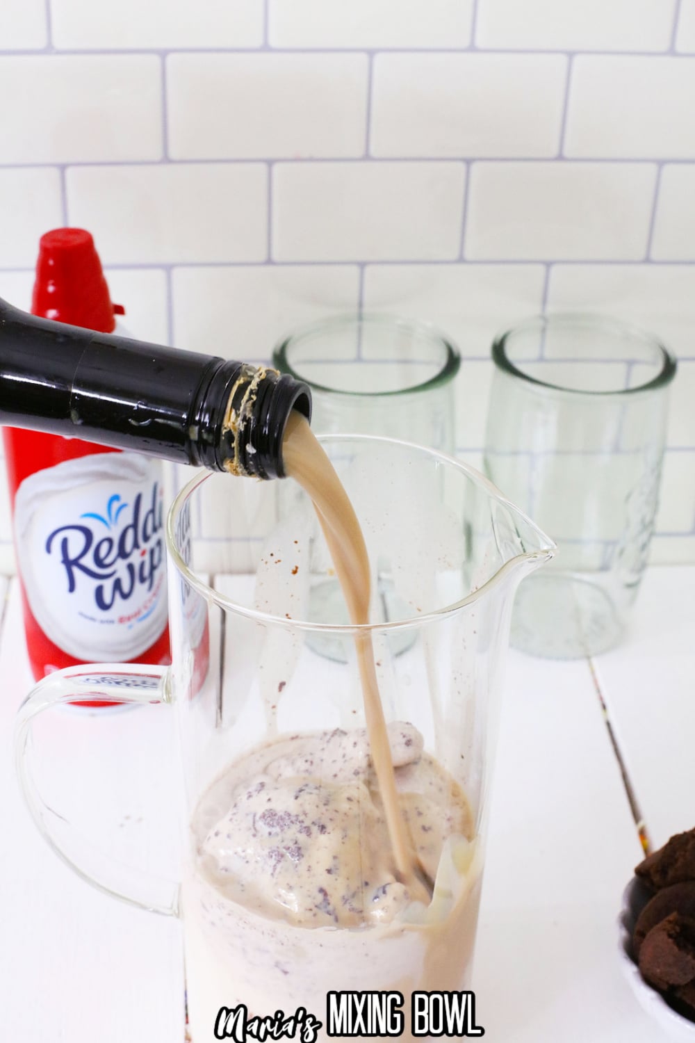 irish cream being poured into a pitcher with ice cream in it