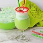 boozy grinch punch with a cherry on it with the name in text for pinterst