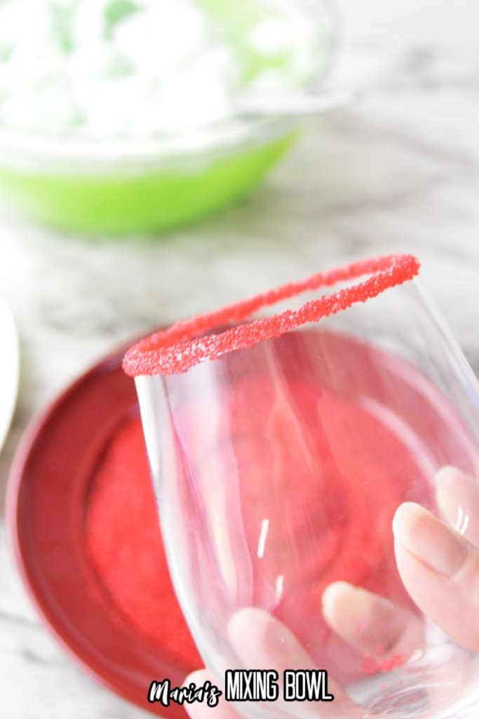 glass being dipped in red sanding sugar