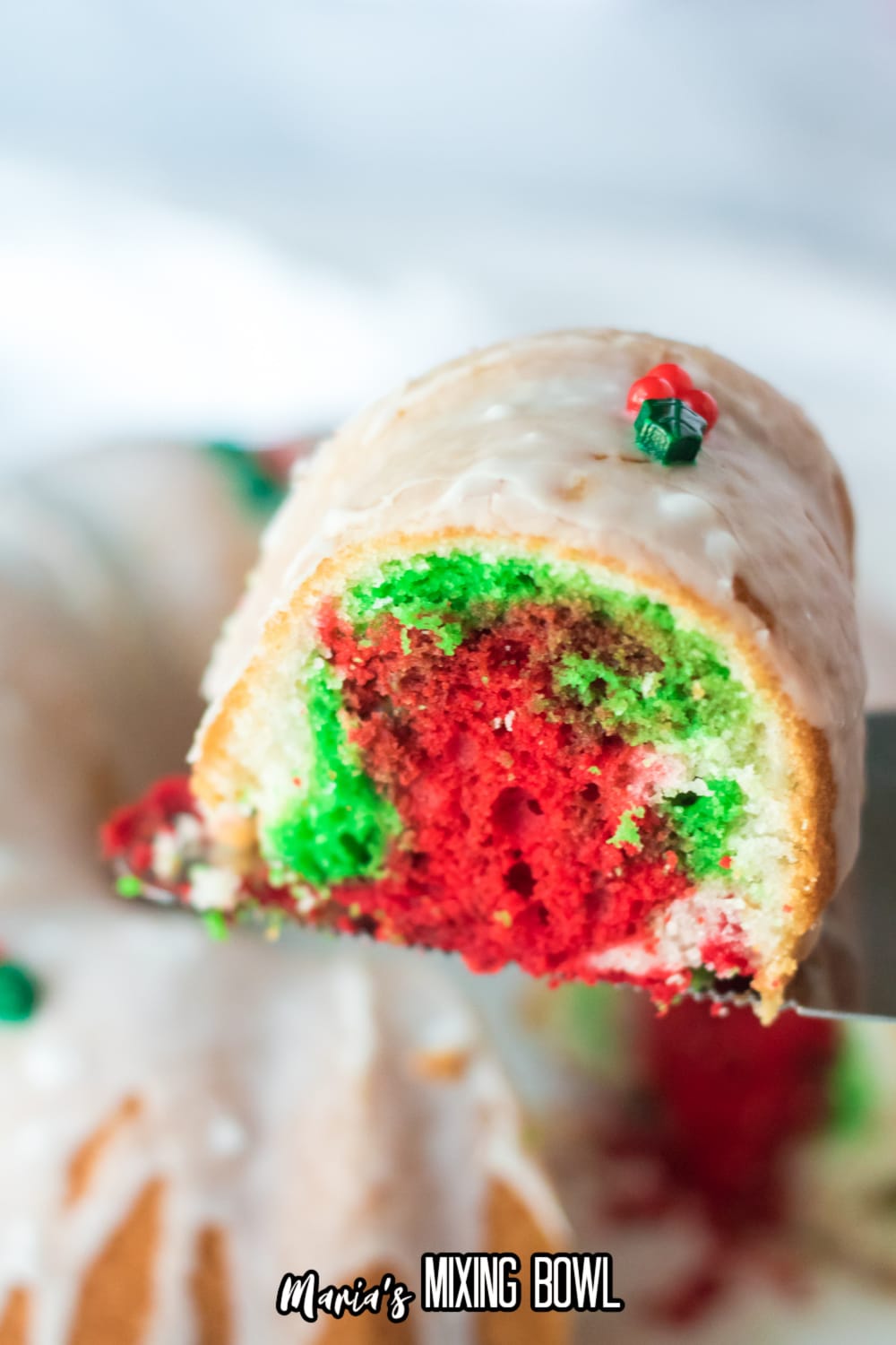 slice of christmas bundt cake held on a spatula in the air