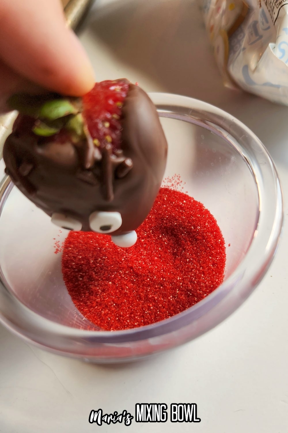 dessert being dipped in red sprinkles