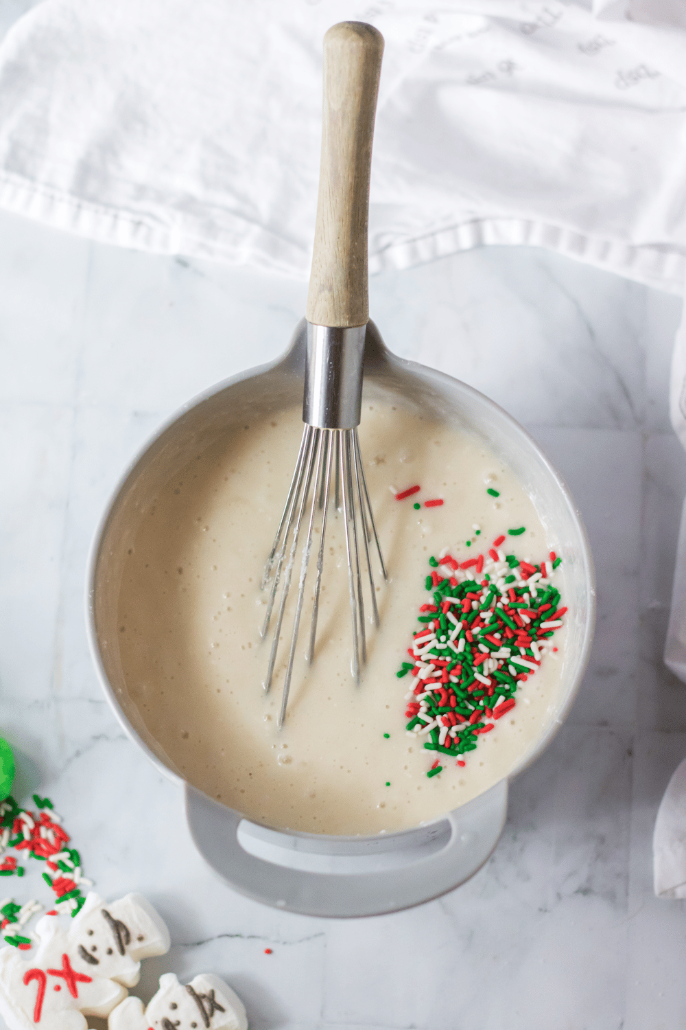 batter and sprinkles in a white bowl iwth a whisk