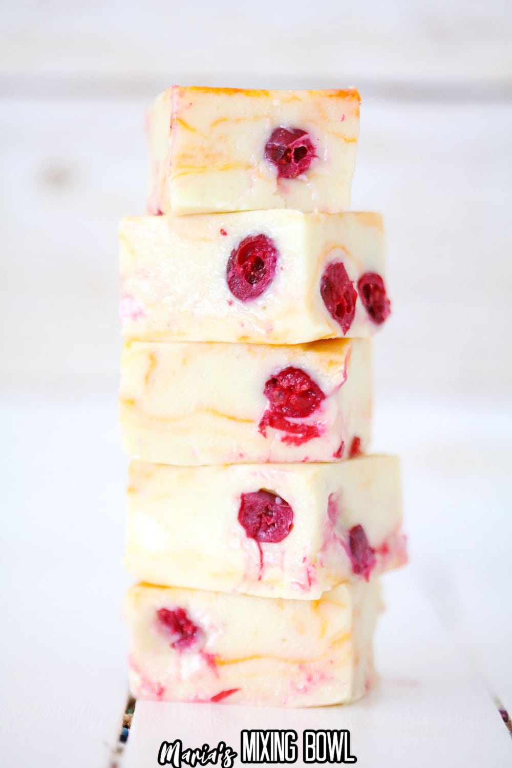 stack of cranberry orange fudge on a white backdrop