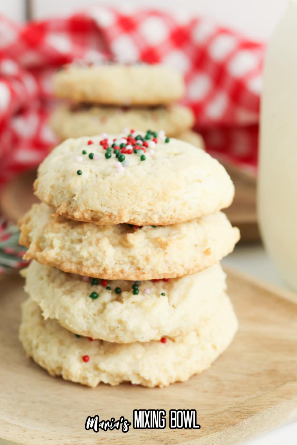 stack of four cream cheese sugar cookies on a wooden cutting board