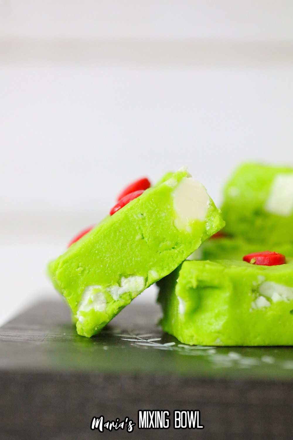 two pieces of grinch fudge on a dark backdrop