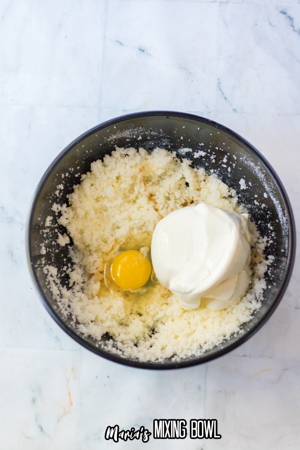 eggs, butter, sugar and ricotta cheese in a dark mixing bowl