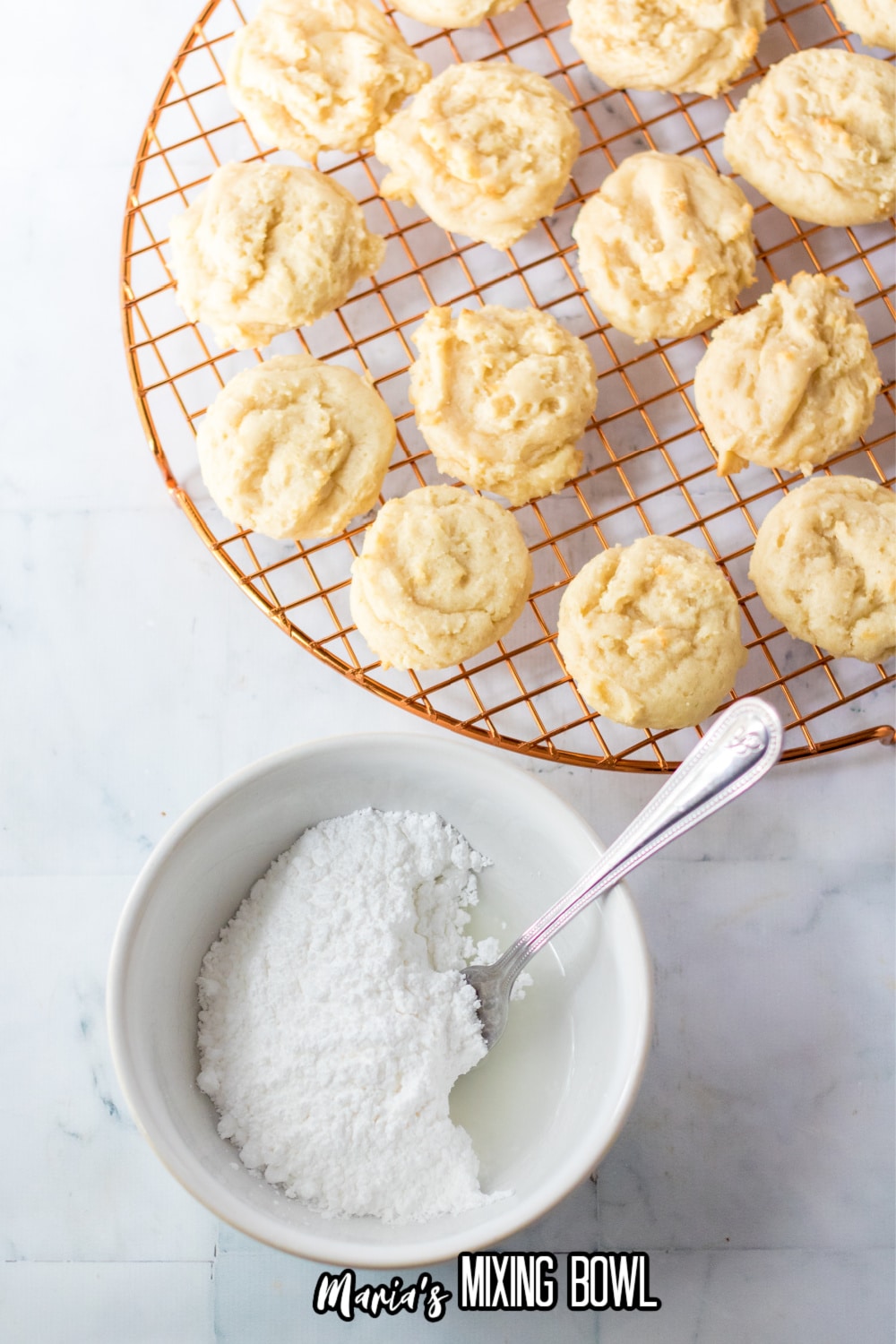 dessert cooling in a cooling rack with powdered sugar and milk in small bowl