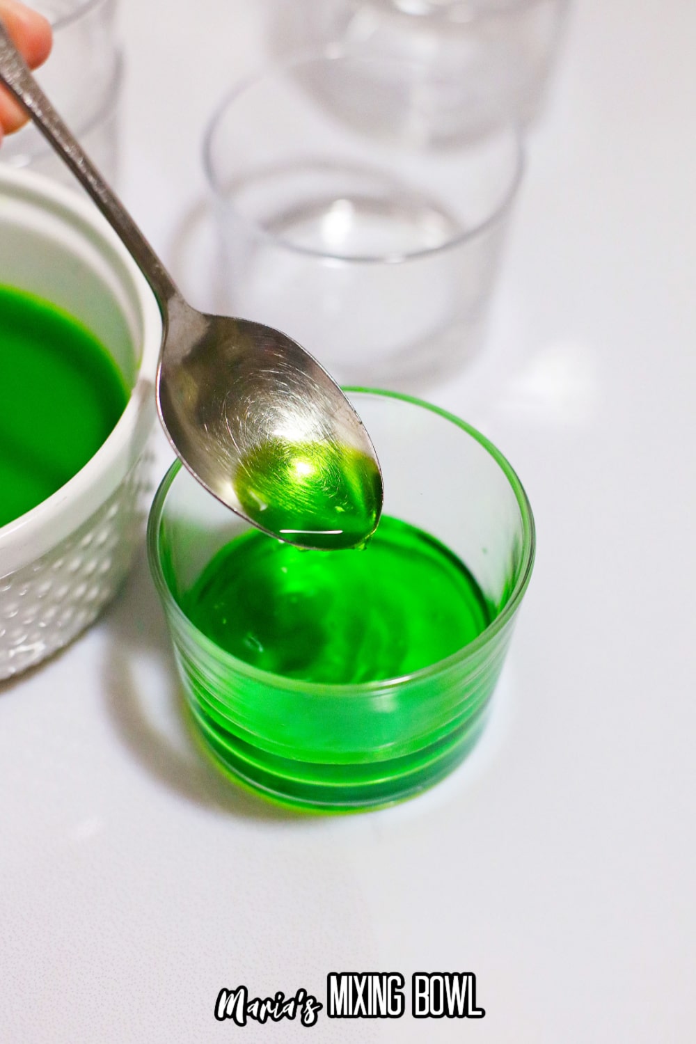 green jello being added to a small glass