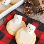 two melting snowman cookies on a red and black napkin
