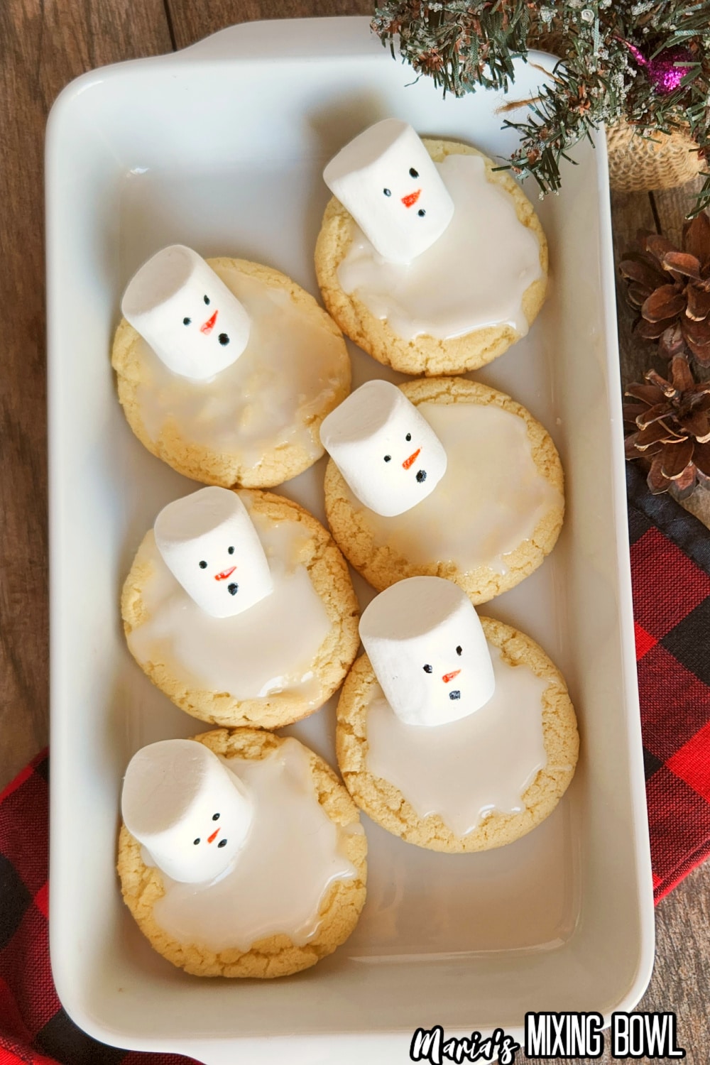 six melting snowman cookies in a white baking dish