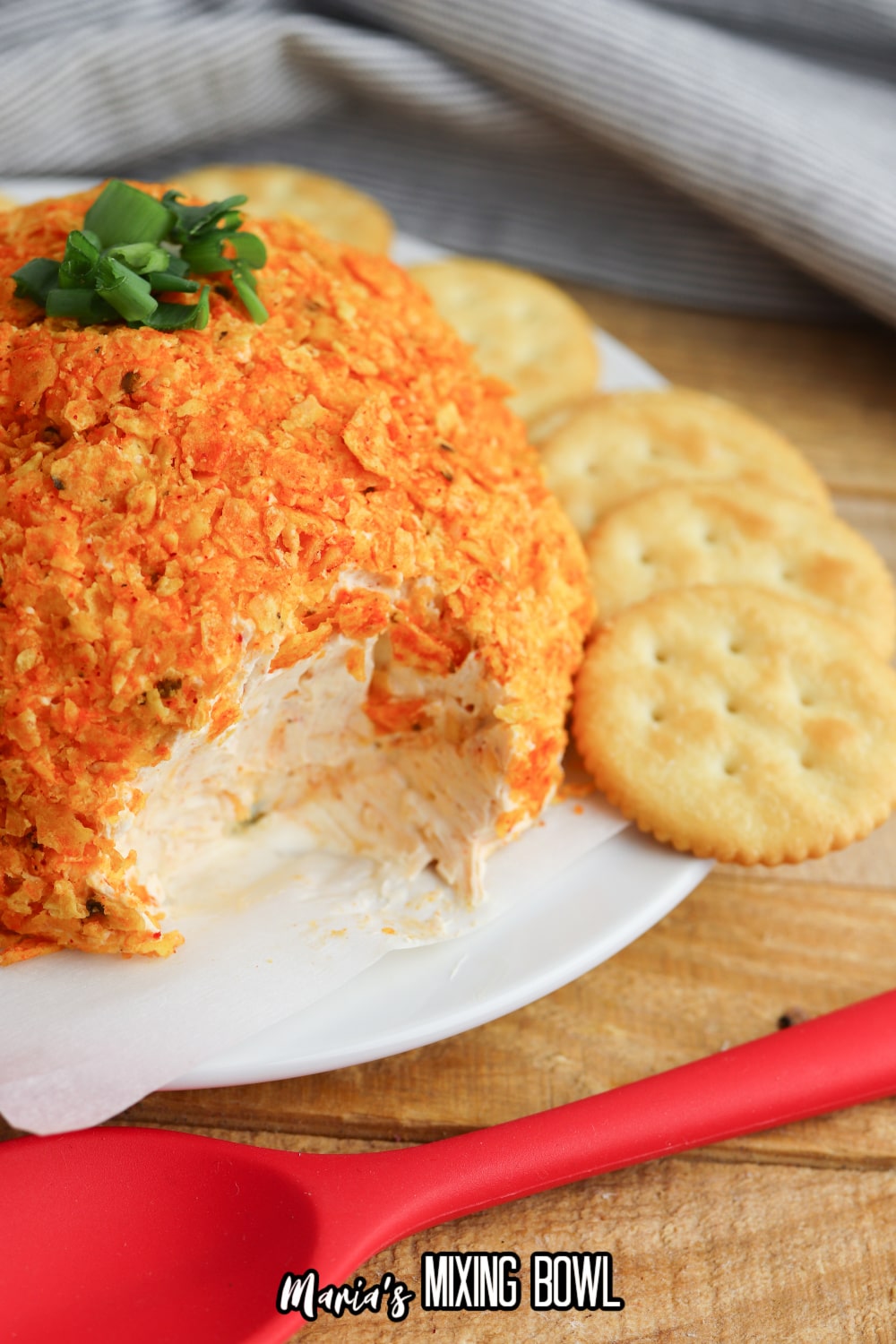 nacho cheese ball on a white plate with a slice missing