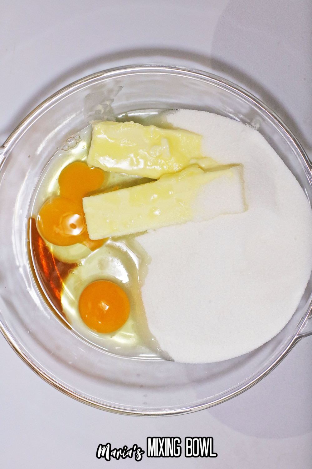 butter, eggs, vanilla, and sugar in a glass mixing bowl