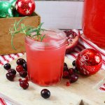 glass of rum cranberry punch on a wooden cutting board