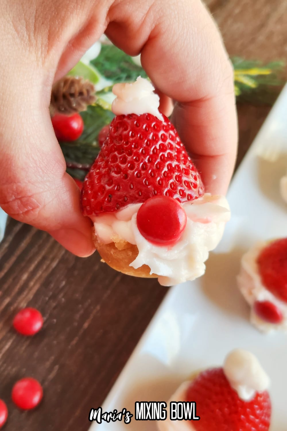 santa gnome cookie cup held in a womens hand in the air