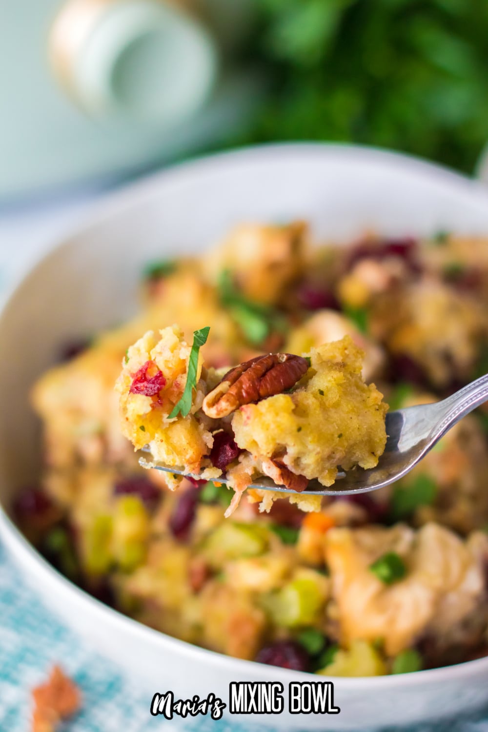 bite of slow cooker cranberry pecan stuffing on a bite held in the air