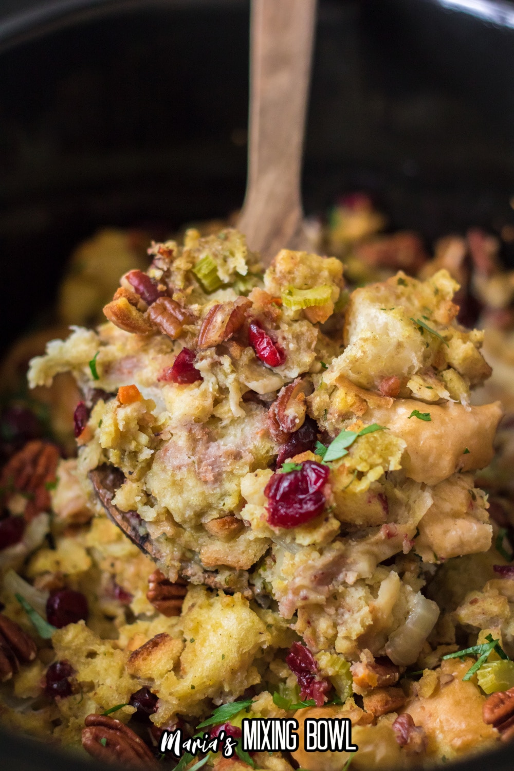 slow cooker pecan stuffing on a wooden spoon