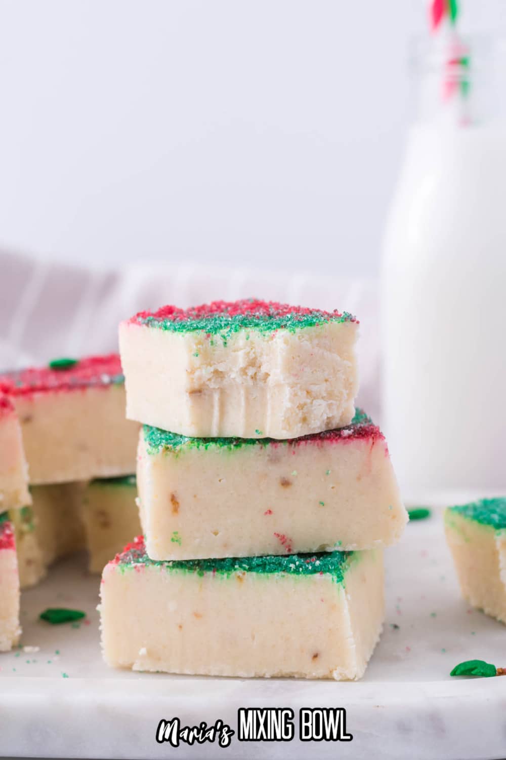 stack of three pieces of sugar cookie fudge. the top has a bite missing