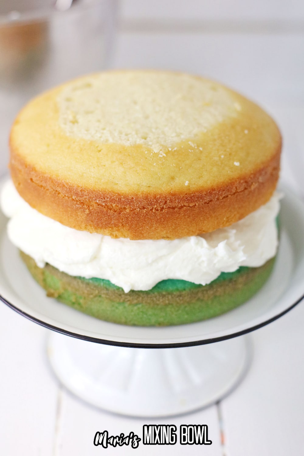 colored cakes being stacked on a cake stand