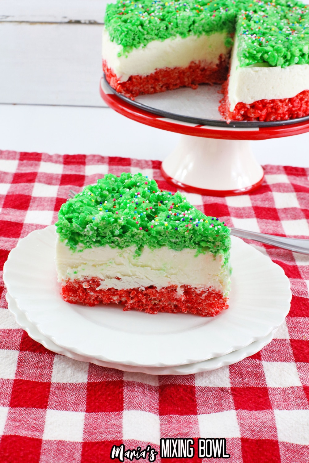 slice of christmas rice krispy crust cheesecake on a white plate