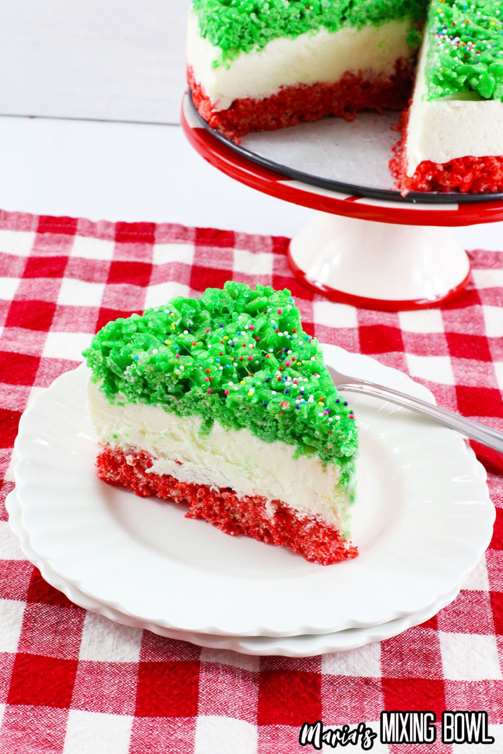 slice of christmas rice krispy crust cheesecake on a white plate