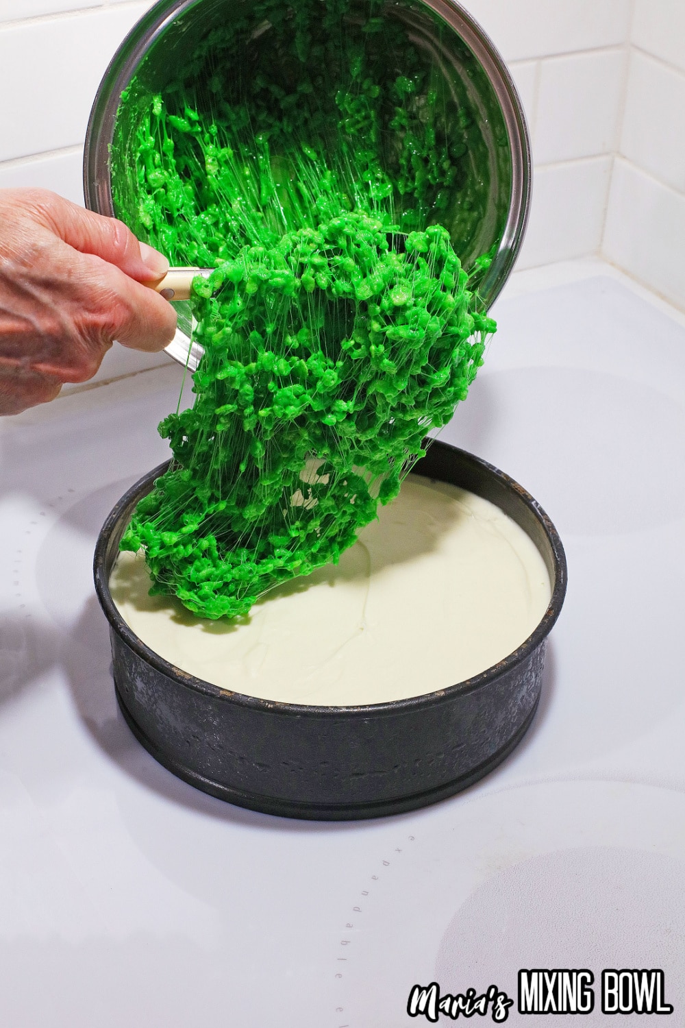 green rice krispies treats on a cheesecake layer