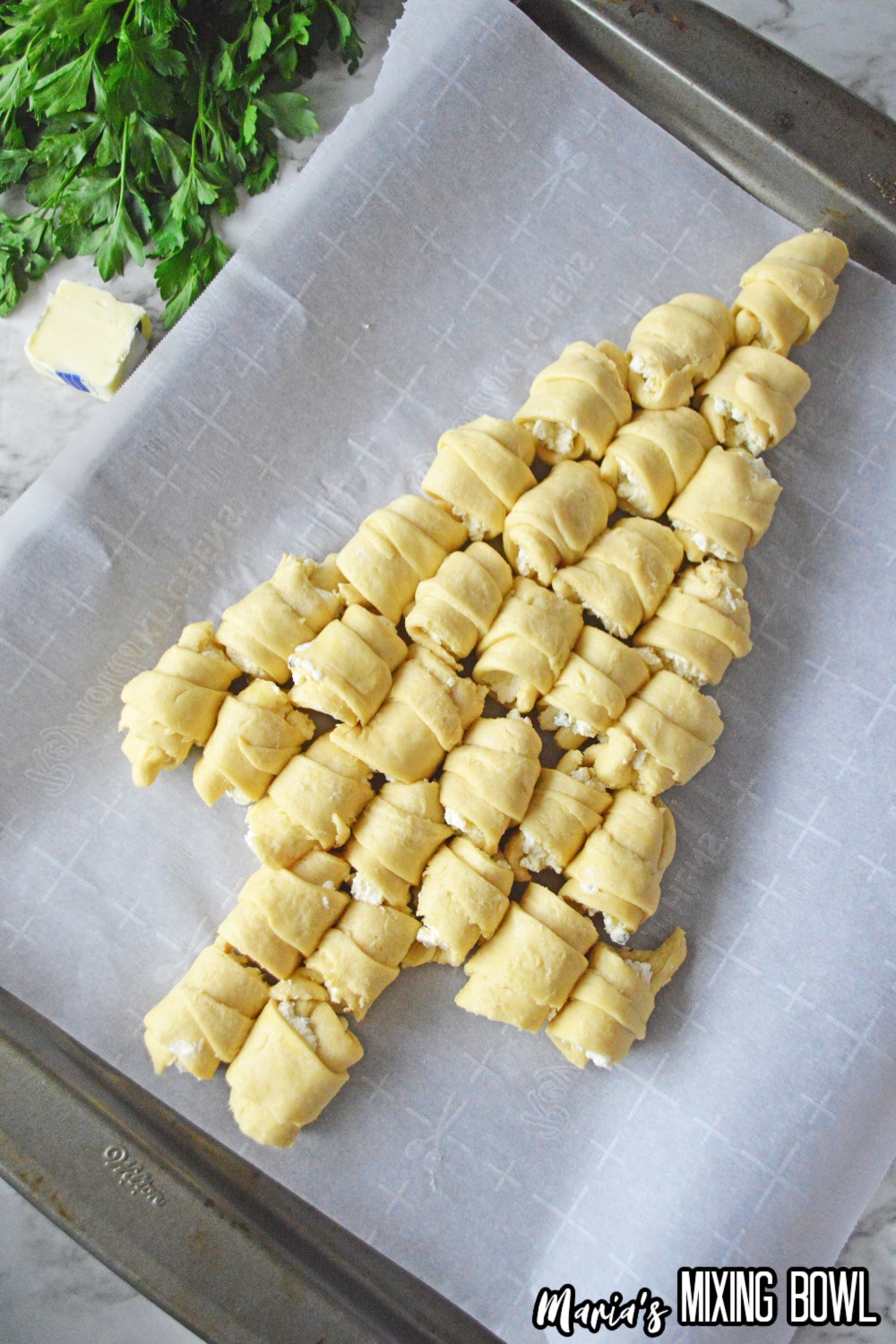 crescent rolls stuffed with cheese on a parchment lined baking sheet