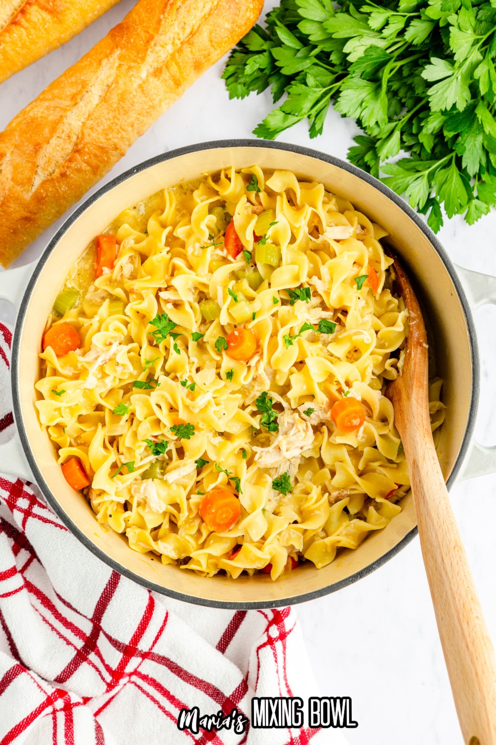 dutch oven filled cafeteria noodles with a wooden spoon