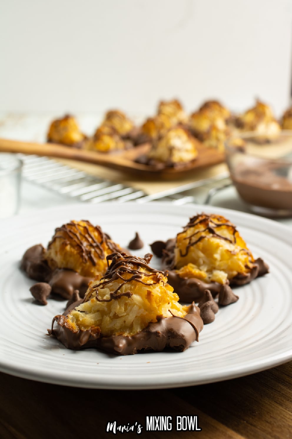 three chocolate covered macaroons on a white plate