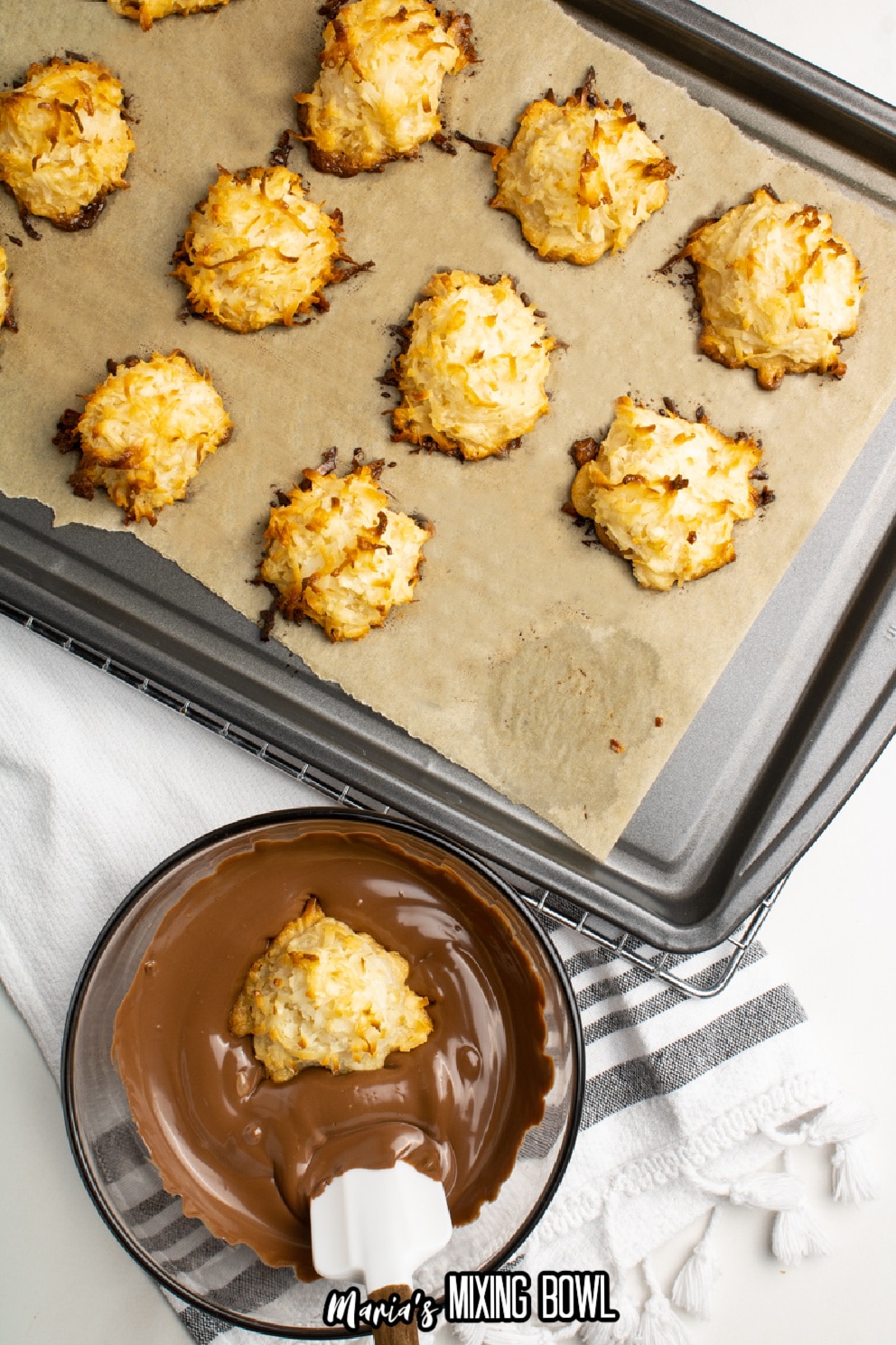 chocolate covered macaroon being dipped in a bowl of melted chocolate