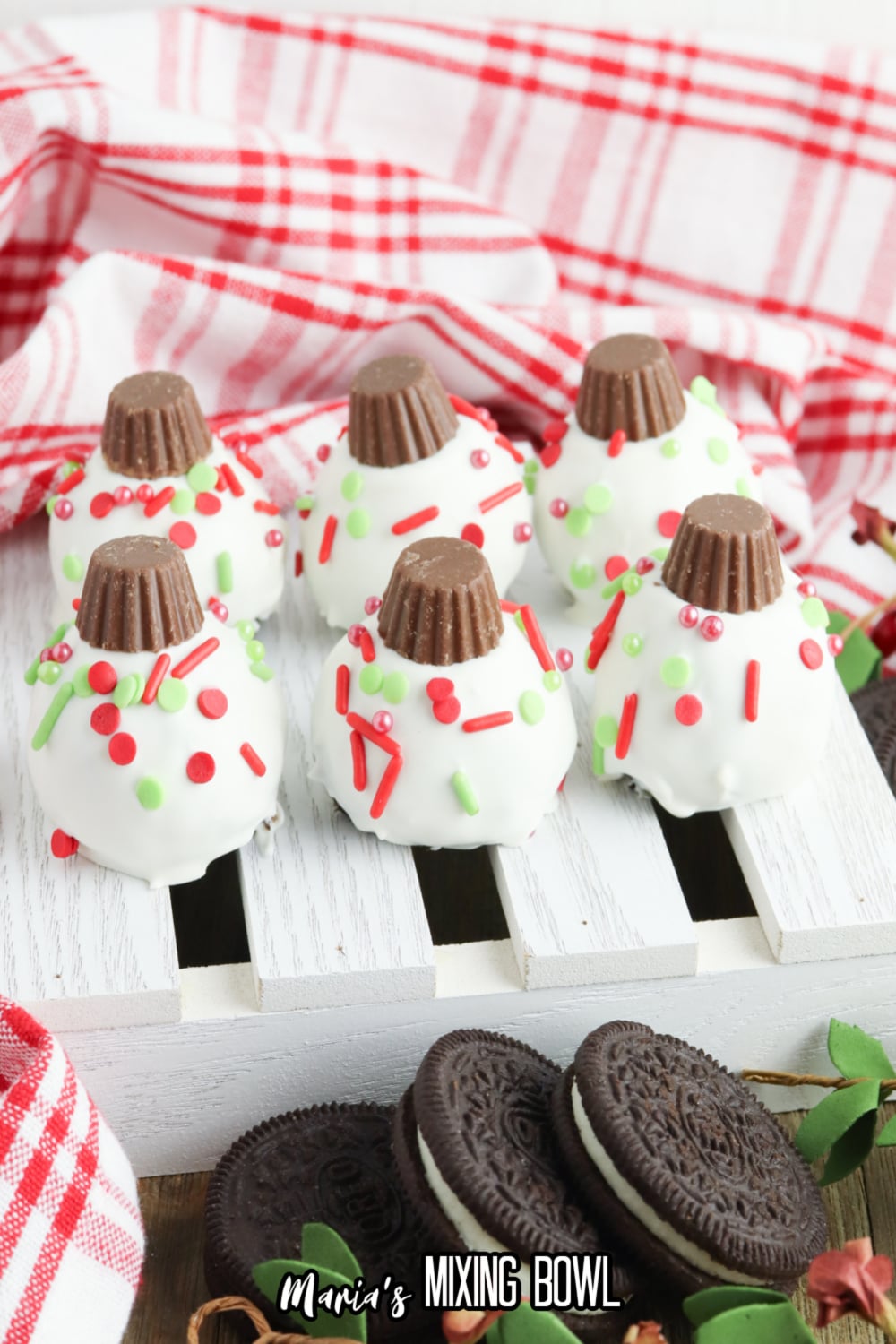 six christmas oreo balls on a white mini wooden pallet