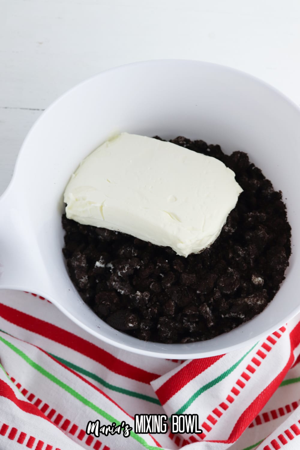 crushed oreos in a white mixing bowl with cream cheese