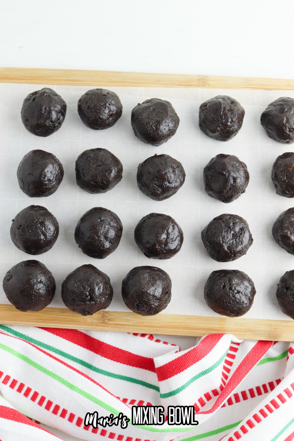 undipped oreo balls on a parchment lined wooden cutting board