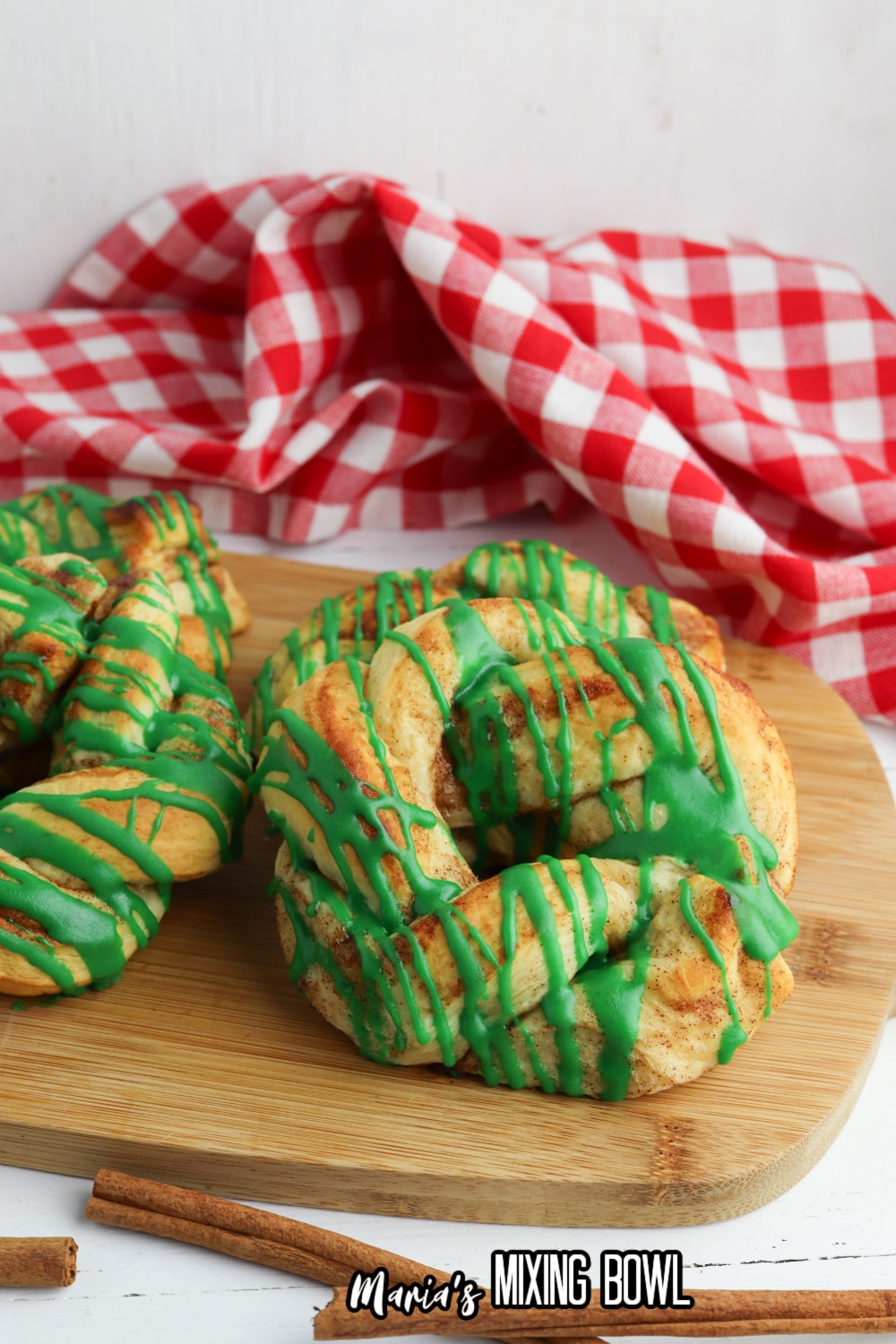 two cinnamon roll wreaths on a wooden cutting board