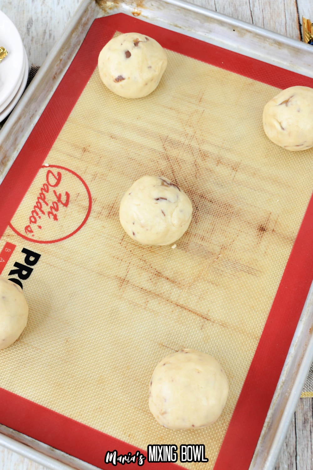 dough balls on a silicone mat lined baking sheet