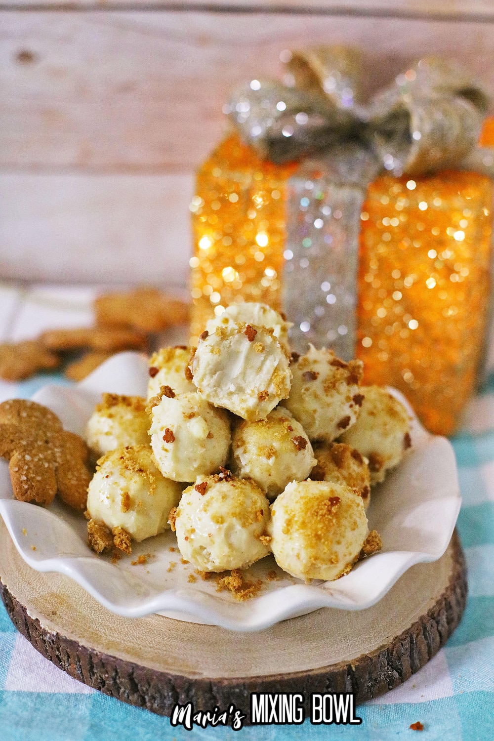 stack of gingerbread truffles on a white scalloped plate with the fake gift in the background