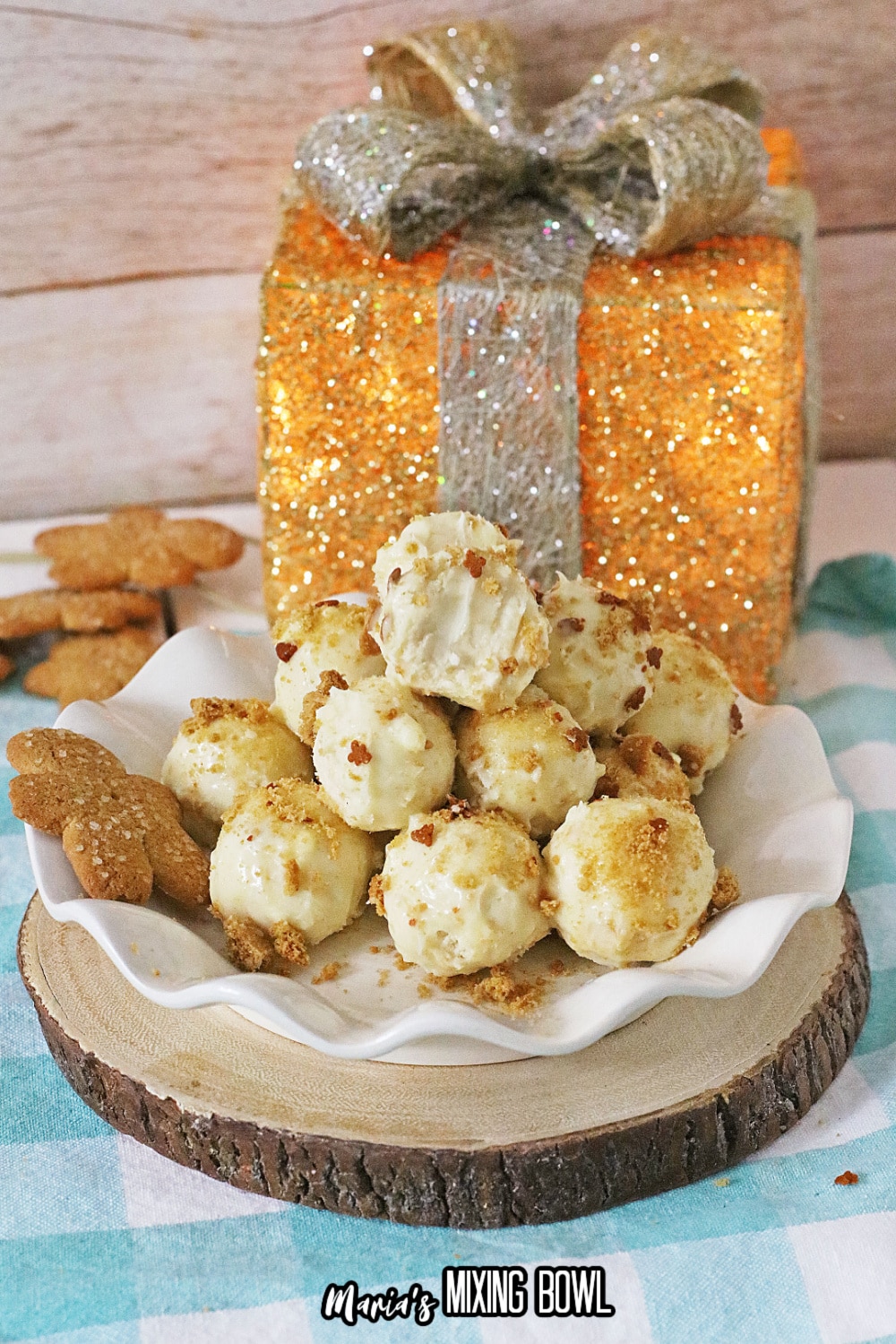 stack of gingerbread truffles on a white scalloped plate with the fake gift in the background