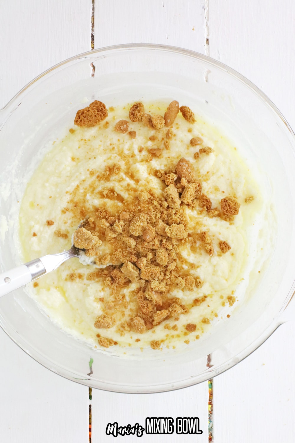 white chocolate, powdered sugar and crumbled cookies in a glass mixing bowl