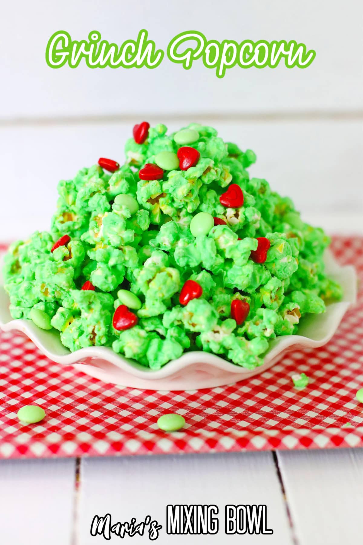 white plate on a red and white kitchen towel filled with grinch popcorn with the name in text for pinterest