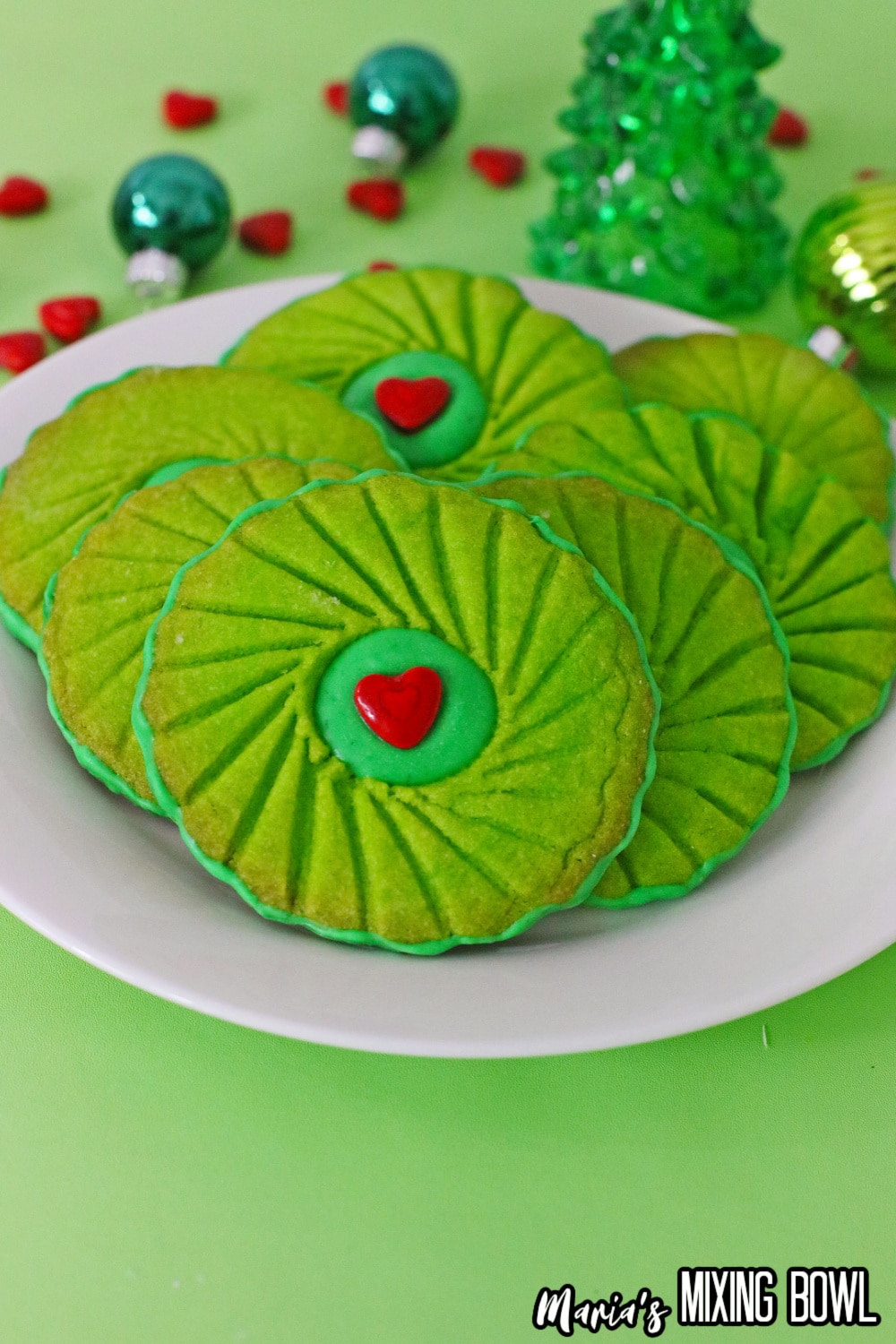 close up of grinch thumbprint cookies on a white plate