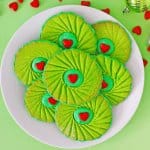 birds eye image of grinch thumbprint cookies with the next in text for pinterest